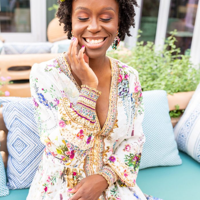 Founder Rosetta Thurman wearing a floral dress and flower crown, smiling with her eyes closed