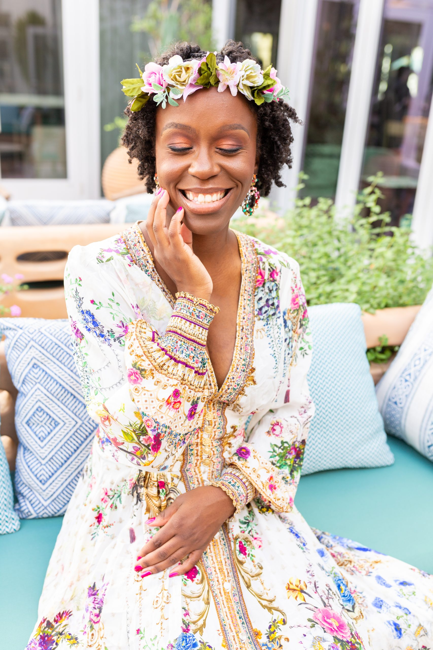 Founder Rosetta Thurman wearing a floral dress and flower crown, smiling with her eyes closed