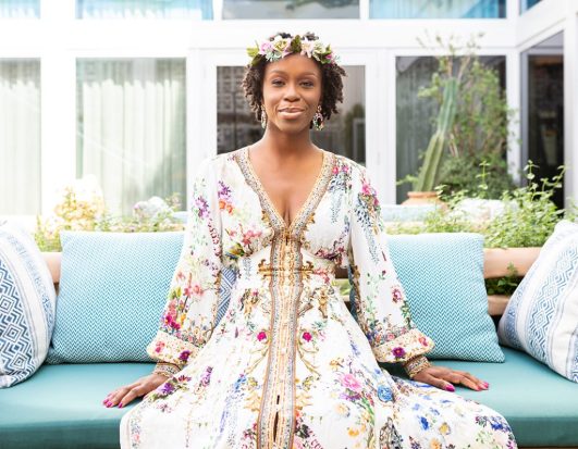 Rosetta Thurman, founder of Happy Black Woman, wearing a floral dress and flower crown looking directly at the camera with a slight smile